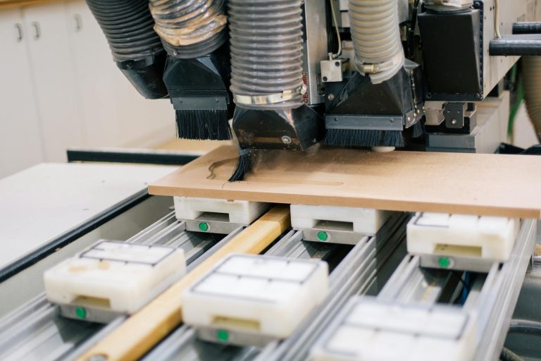 Close-up of a CNC machine carving wood with precision in a workshop setting.